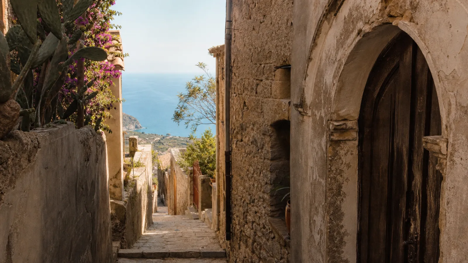 Vicolo in pietra nel centro storico di Nicotera con scorcio sul mare al tramonto