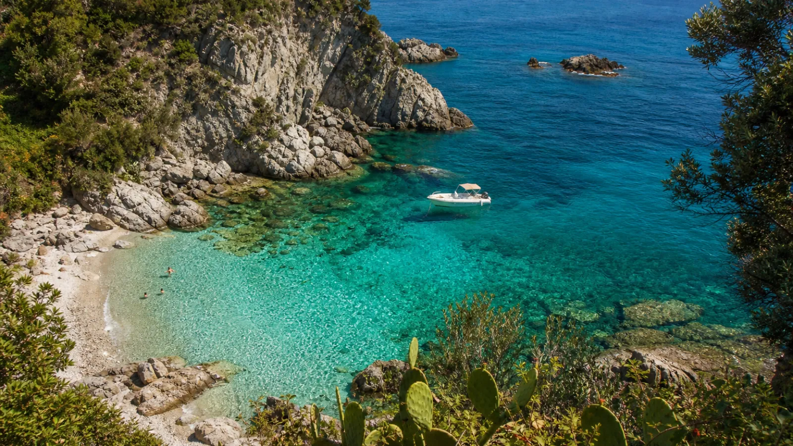 Caletta nascosta con arco naturale e acqua cristallina sulla Costa degli Dei